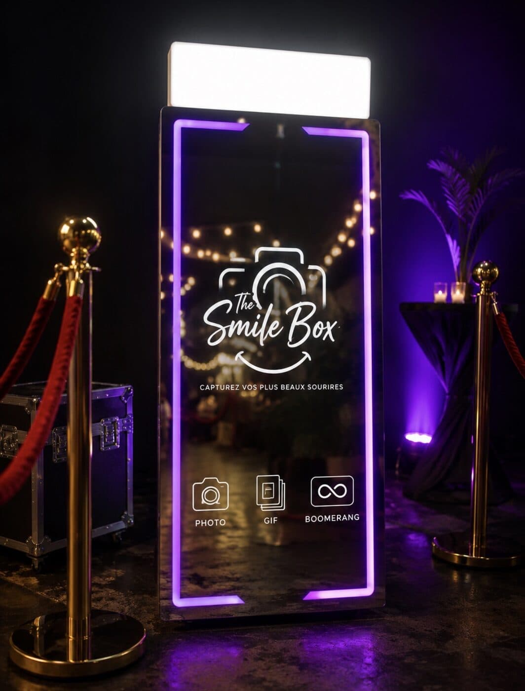 Miroirbooth The Smile Box éclairé en violet à l’entrée d’une soirée